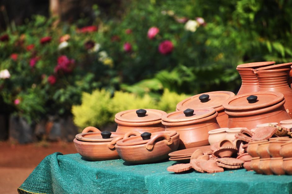 Flessen met terracotta verf staan op tafel.